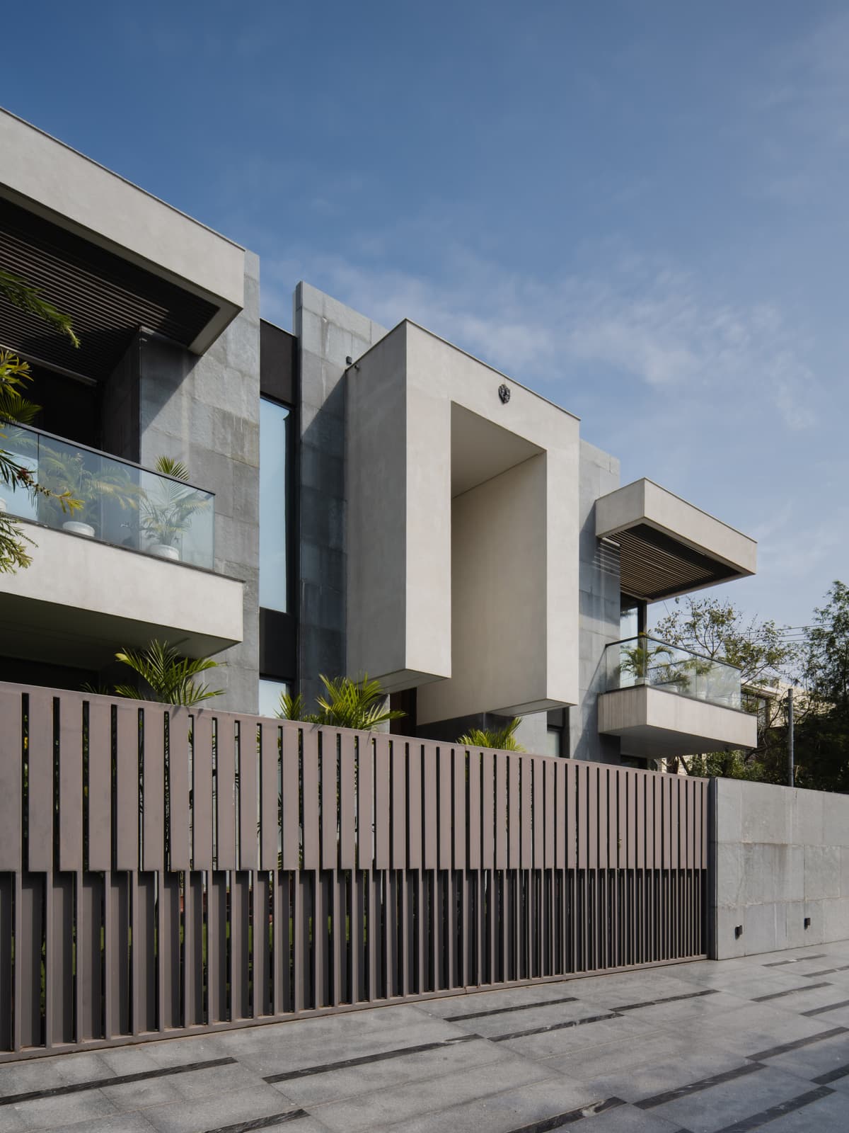 Its white and stone façade is complemented by a sleek boundary wall that protects the private realm within.